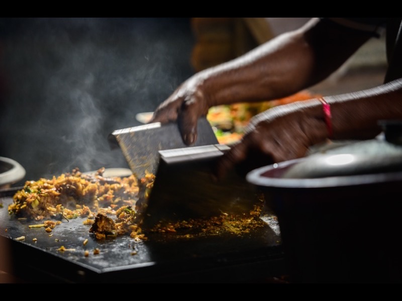 Kottu Roti being prepared on a hot griddle at a Sri Lankan street food stall